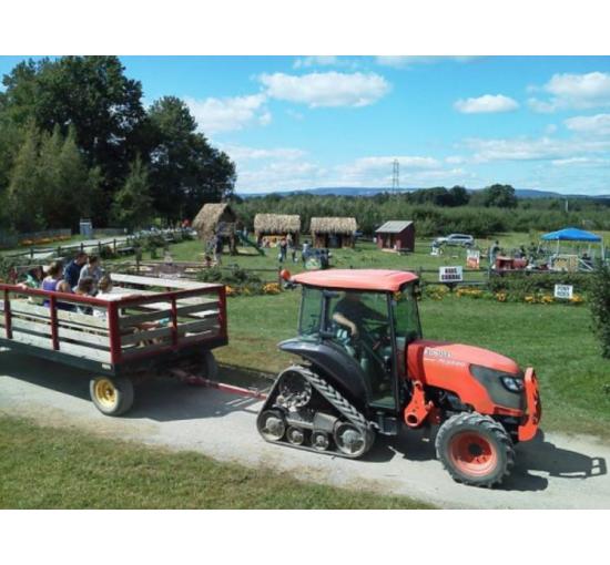 tractor pulling wagon with people in it on the farm at an event