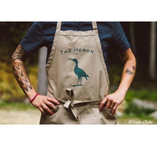 pic of someone wearing an apron with the heron logo