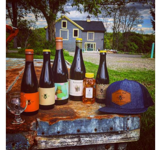 outside on a table sits the bottles plan bee farm brewery sells