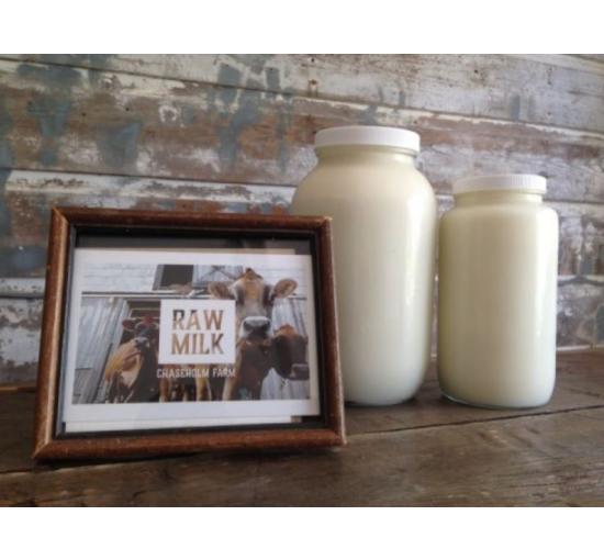 2 containers of raw milk with a sign