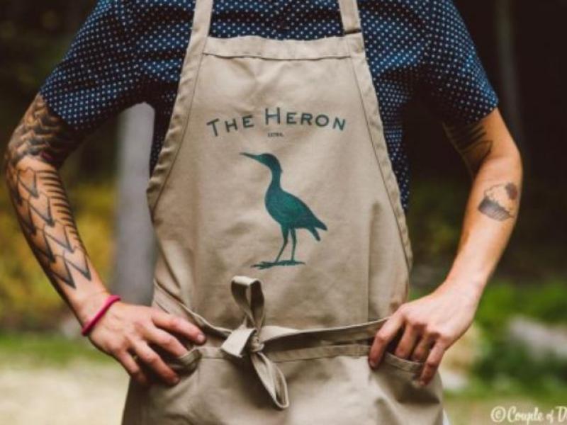 pic of someone wearing an apron with the heron logo
