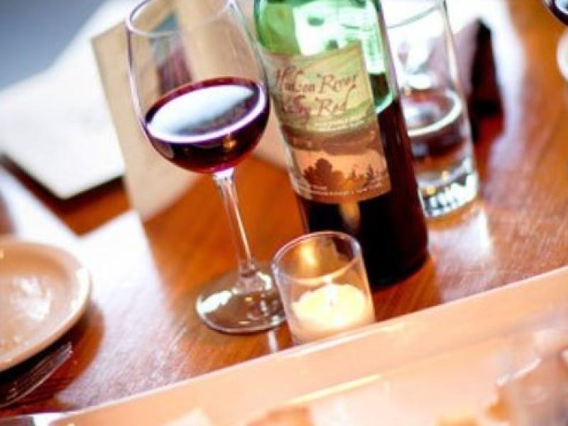cheese plate on a table with wine bottle and glasses of wine