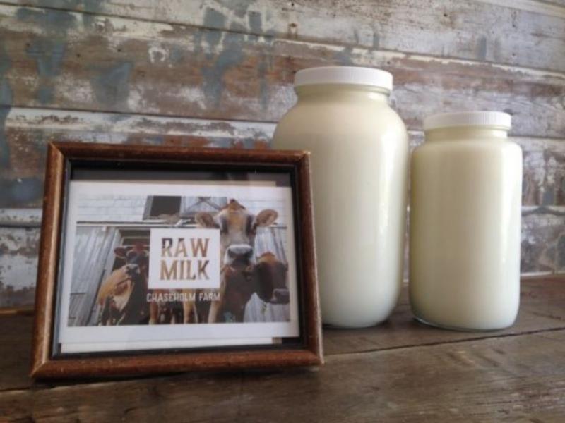 2 containers of raw milk with a sign
