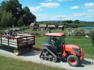 tractor pulling wagon with people in it on the farm at an event